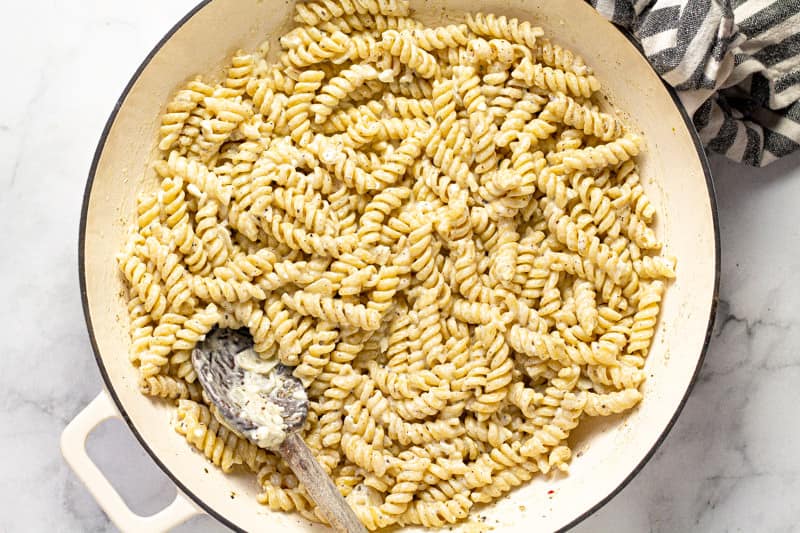 Large white pan filled with cooked noodles and feta sauce