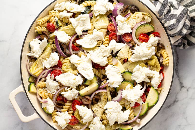 Mediterranean baked pasta topped with fresh mozzarella ready to be baked in the oven
