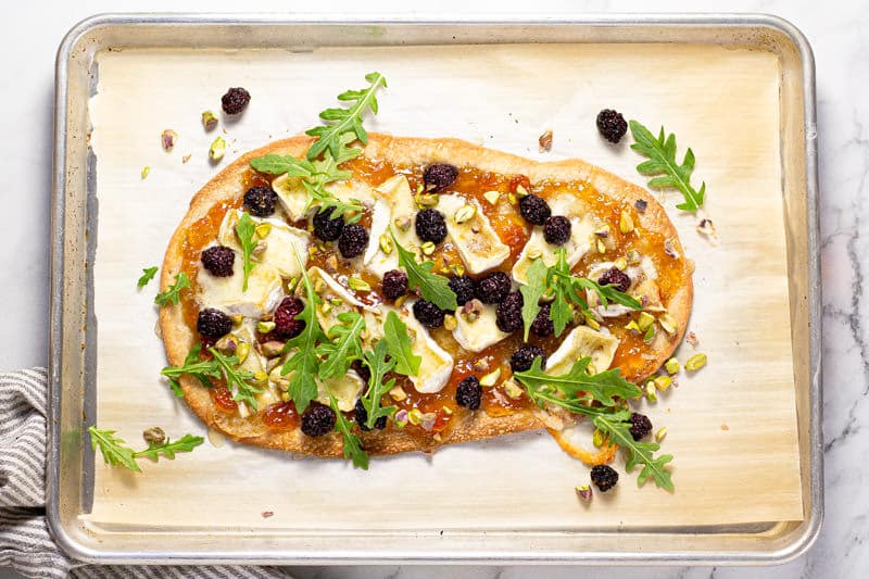 Brie blackberry flatbread on a parchment lined baking sheet