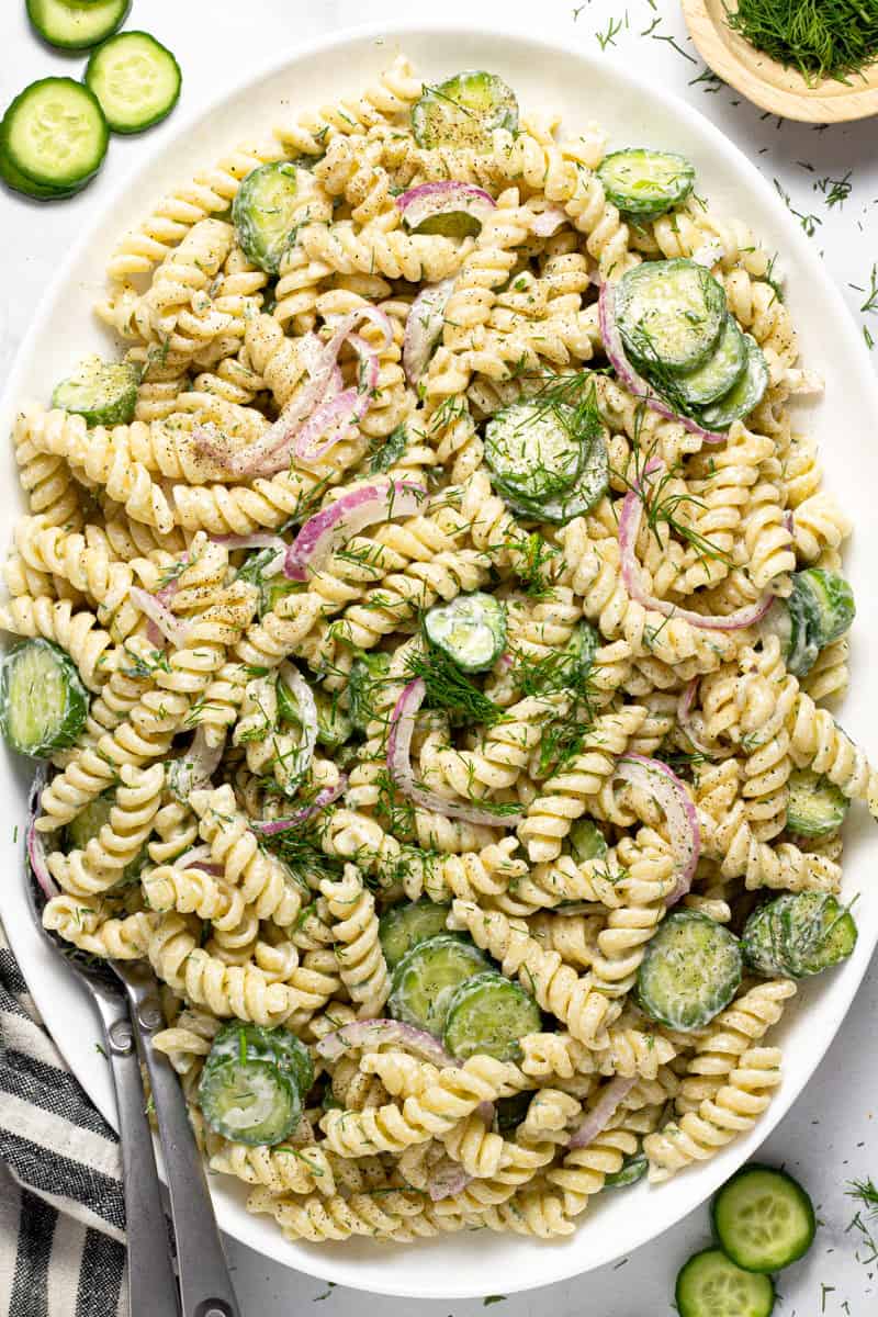 Large white platter filled with creamy vegan cucumber pasta salad 