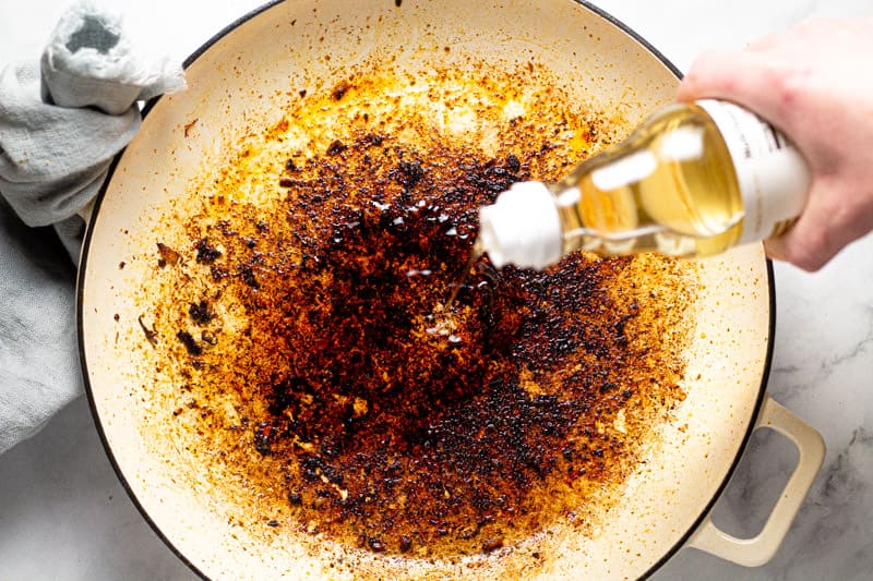 Large white pan with rice vinegar being poured into it