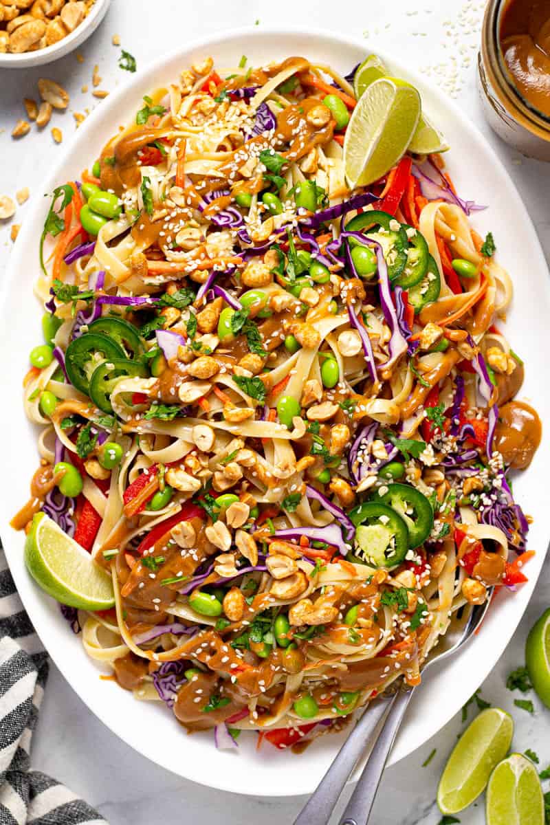 Large white platter filled with vegan peanut pasta salad garnished with fresh cilantro