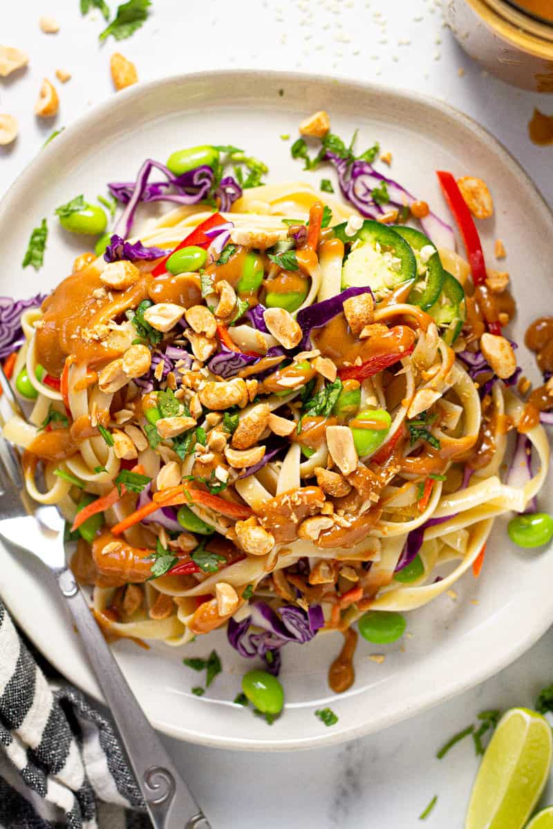 Plate filled with vegan peanut pasta salad garnished with green onions