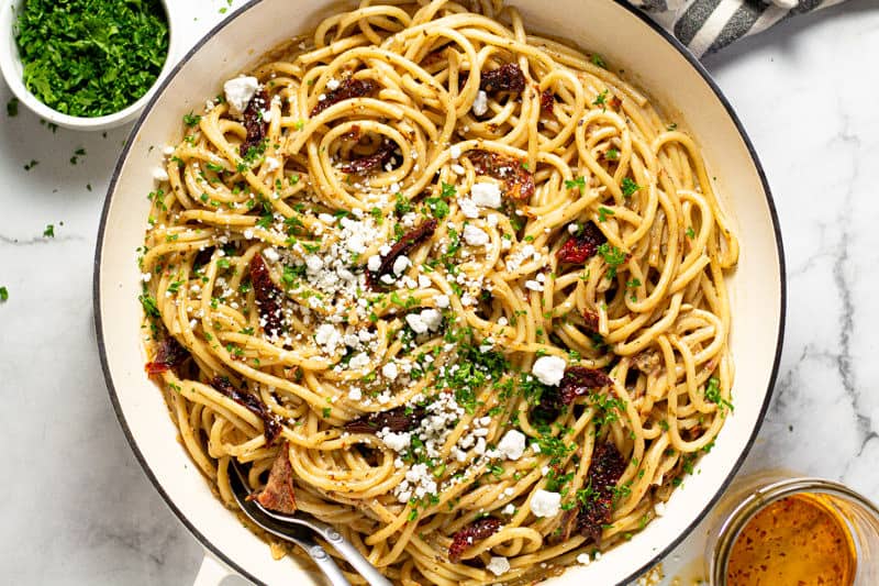 Overhead shot of a large white pan filled vegan sun dried tomato pasta