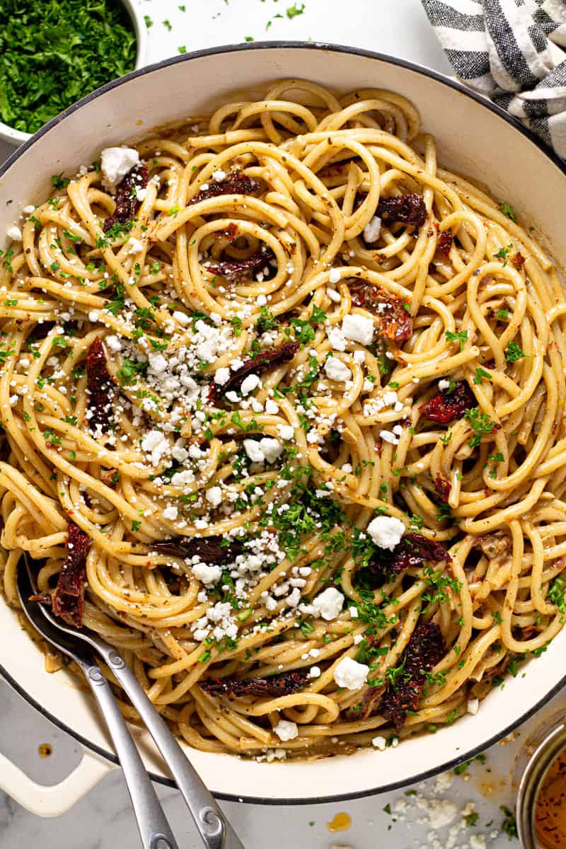 Overhead shot of a large white pan filled vegan sun dried tomato pasta