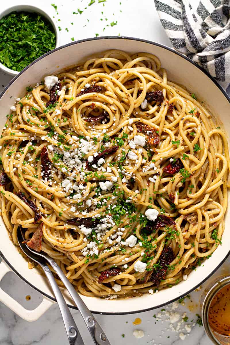 Overhead shot of a large white pan filled vegan sun dried tomato pasta