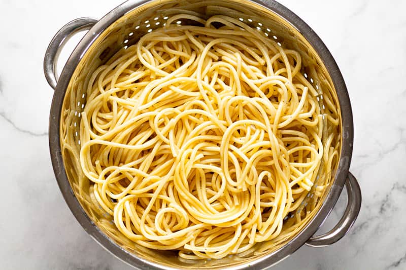 Cooked pasta in a metal strainer