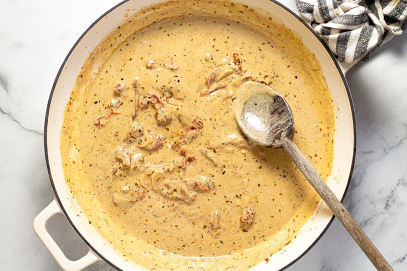 A large white pan with sun dried tomato cream sauce in it