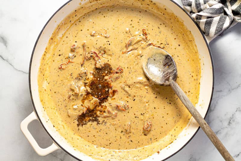 A large white pan with sun dried tomato cream sauce in it