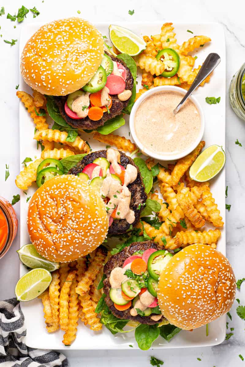 Large white platter filled with three Banh Mi burgers and crispy baked fries