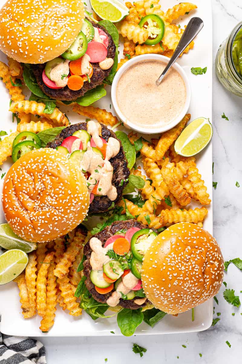 Large white platter filled with three Banh Mi burgers and crispy baked fries