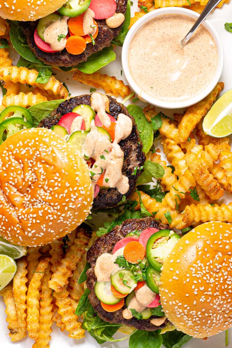 Large white platter filled with three Banh Mi burgers and crispy baked fries