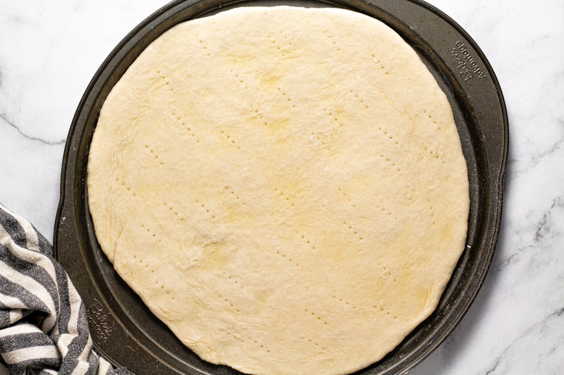 Round pizza pan with a pizza crust on it 