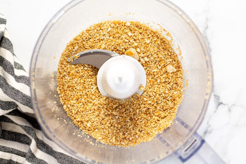 Overhead shot of a food processor filled with Ritz cracker crumbs