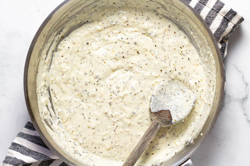 Metal pan filled with creamy feta sauce