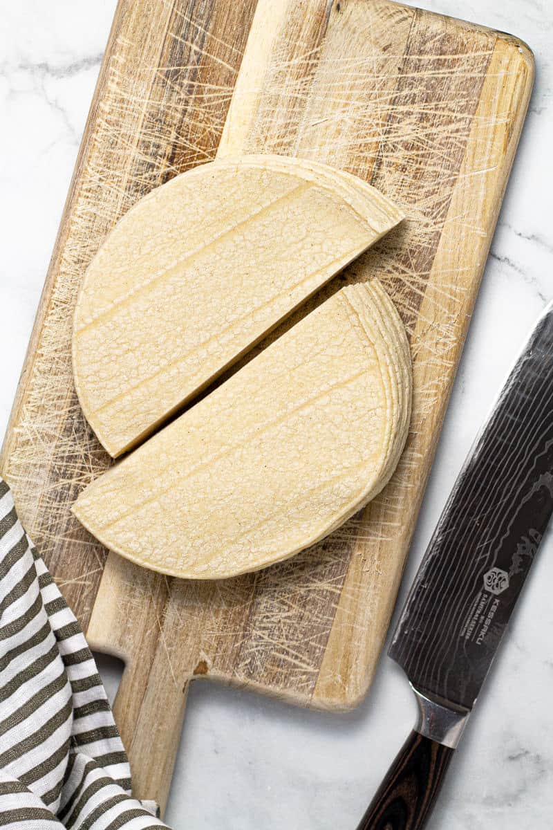 Small cutting board with corn tortillas cut in half
