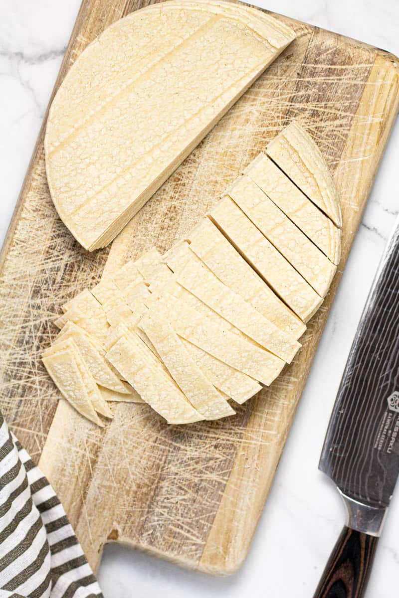 Small cutting board with sliced corn tortillas on it