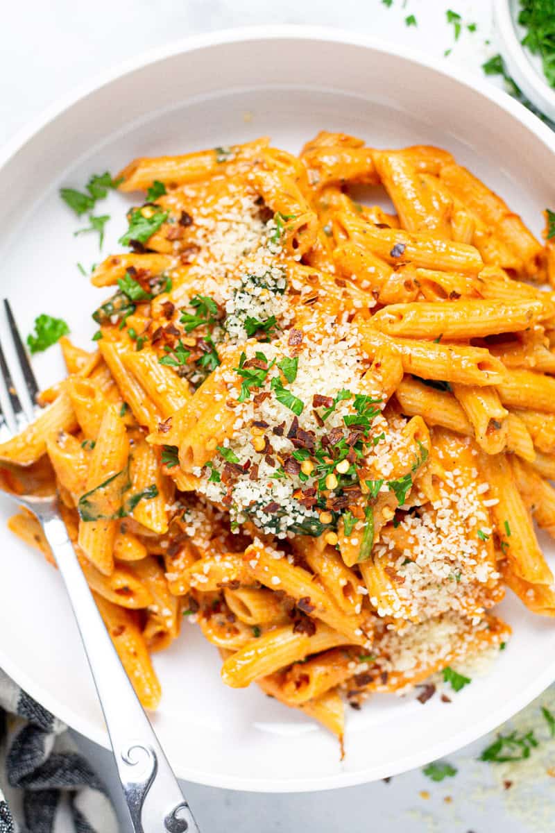 Large white bowl with homemade penne rosa garnished with fresh parsley 