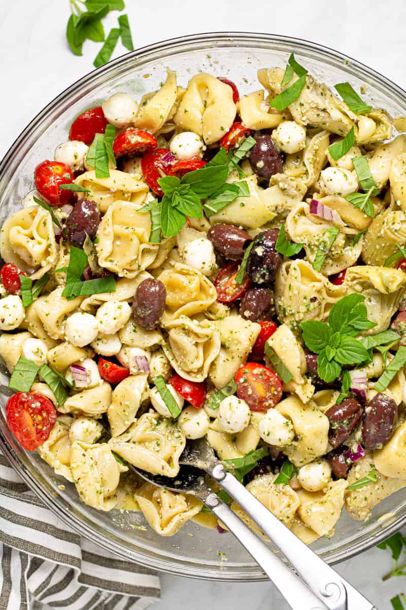 Large glass bowl filled with ingredients to make basil pesto pasta salad