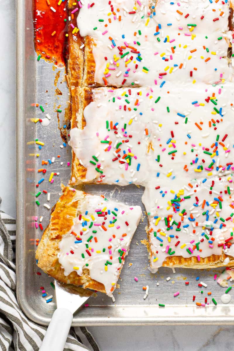 Giant strawberry pop tart on a large sheet pan with rainbow sprinkles