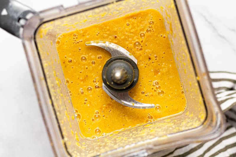 Overhead shot of a blender filled with creamy corn soup 