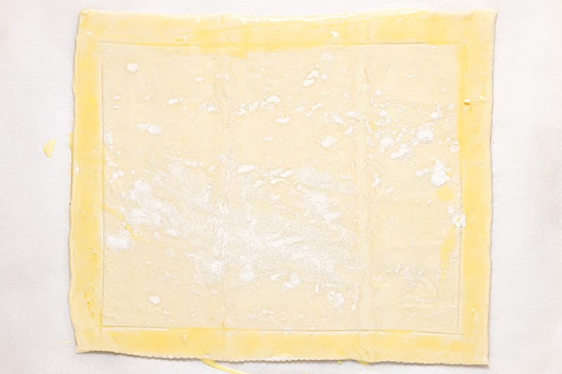 Rolled out and scored puff pastry brushed with egg wash