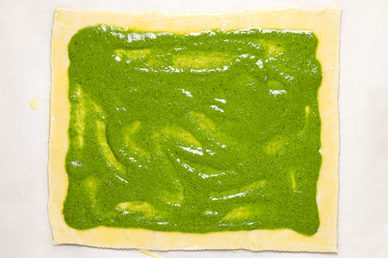 Sheet of puff pastry spread with homemade basil pesto