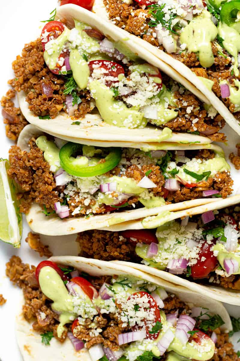 Close up shot of vegan tacos drizzled with avocado cream sauce 