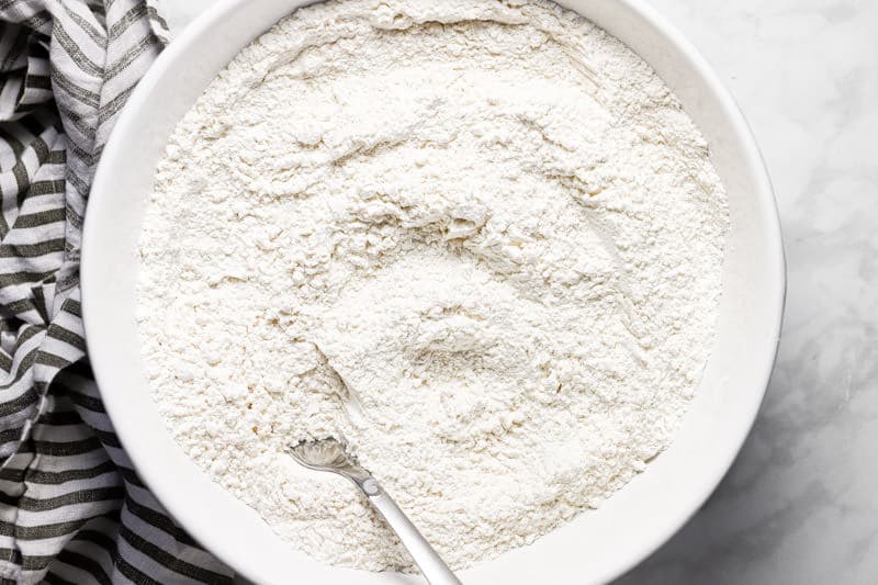 Large white bowl filled with flour salt and baking powder