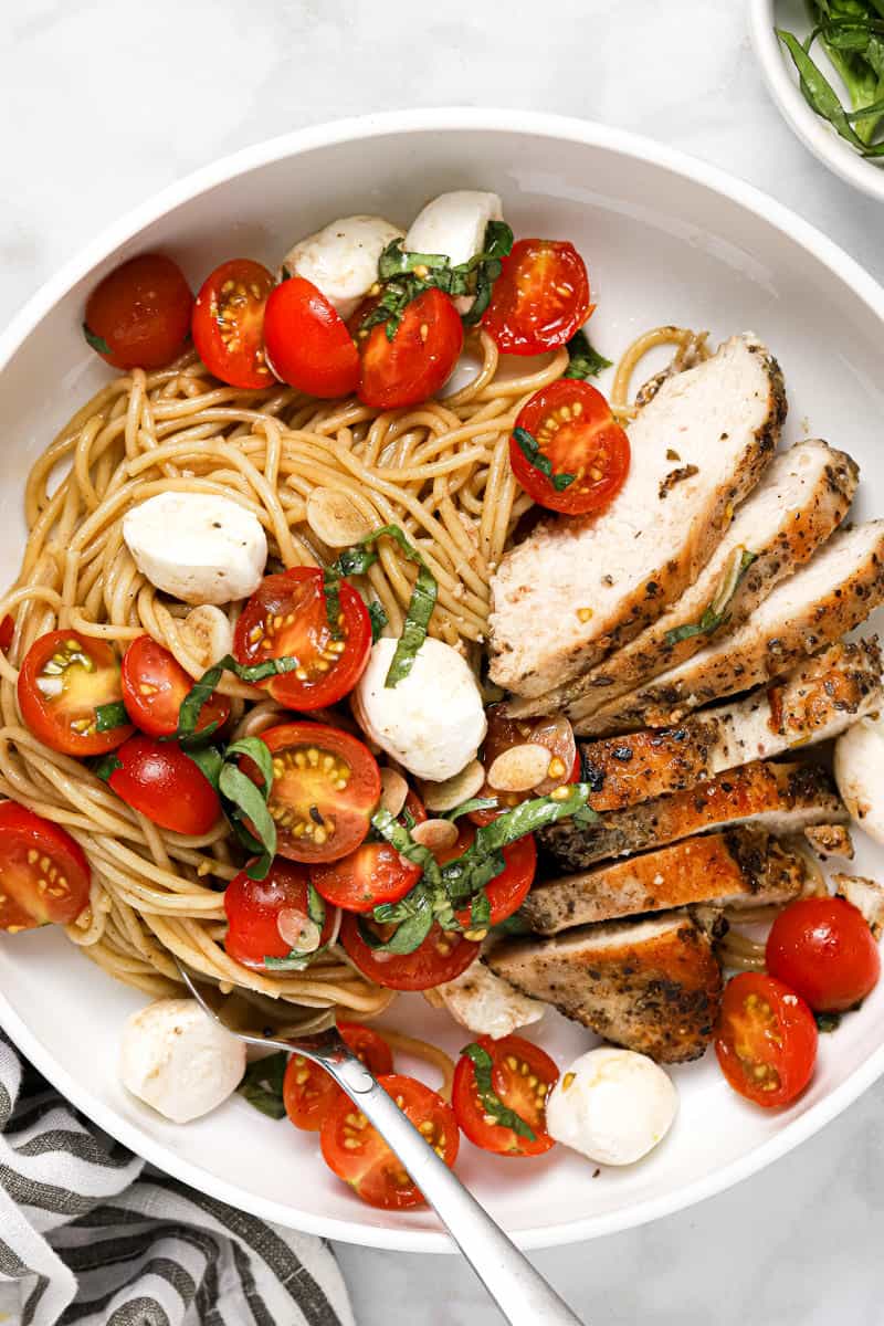 Large white plate filled with spaghetti and bruschetta chicken