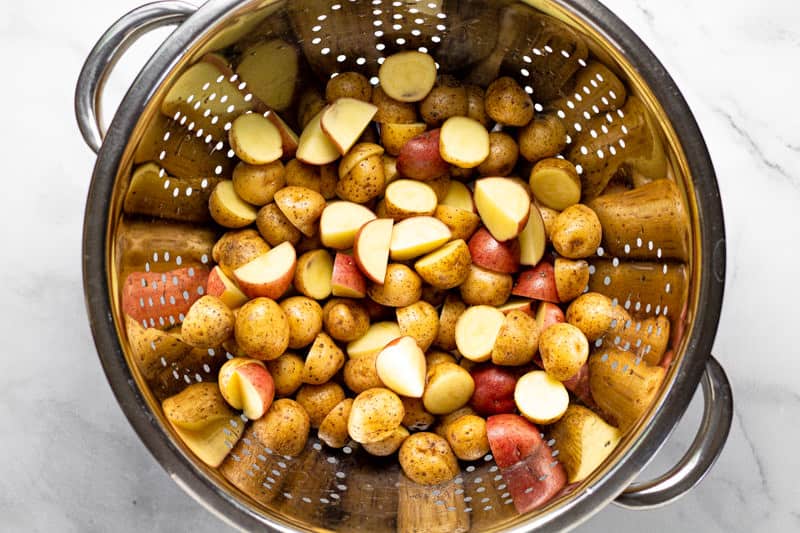 Large metal strainer filled with baby potatoes