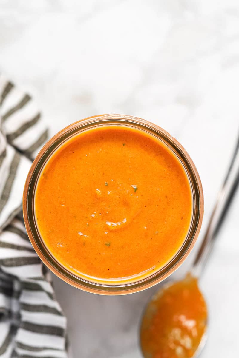 Overhead shot of a mason jar with creamy roasted tomato sauce in it