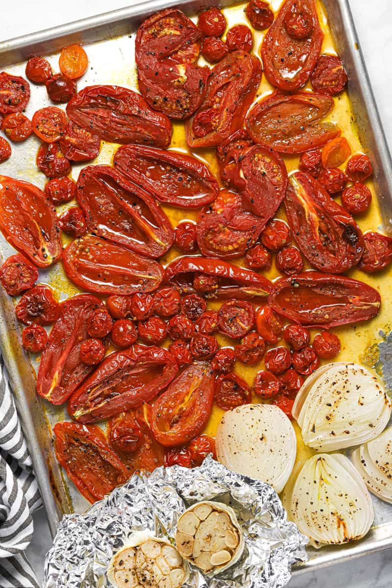 Roasted tomato onion and garlic on a metal baking sheet