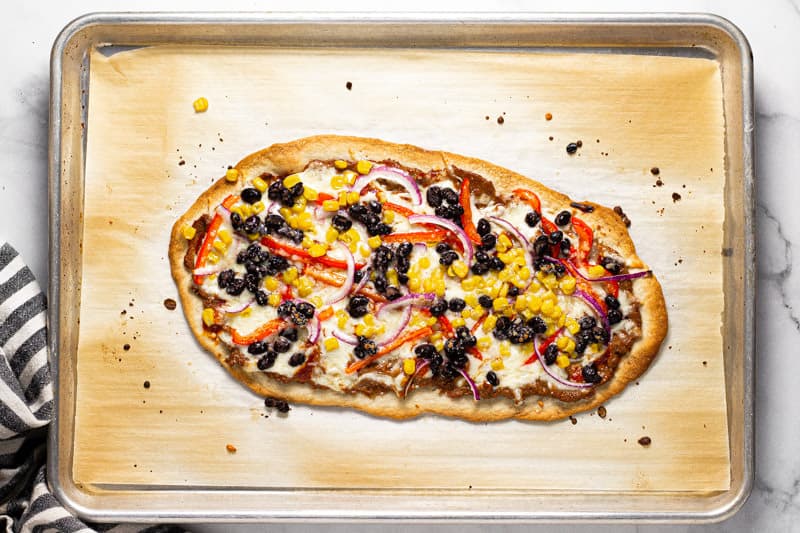 Freshly baked Mexican flatbread pizza on a baking sheet 
