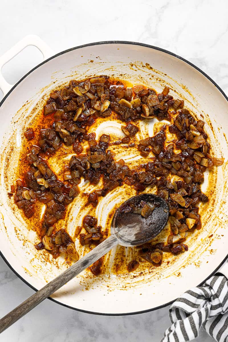 White pan with sauteed onion garlic and spices in it