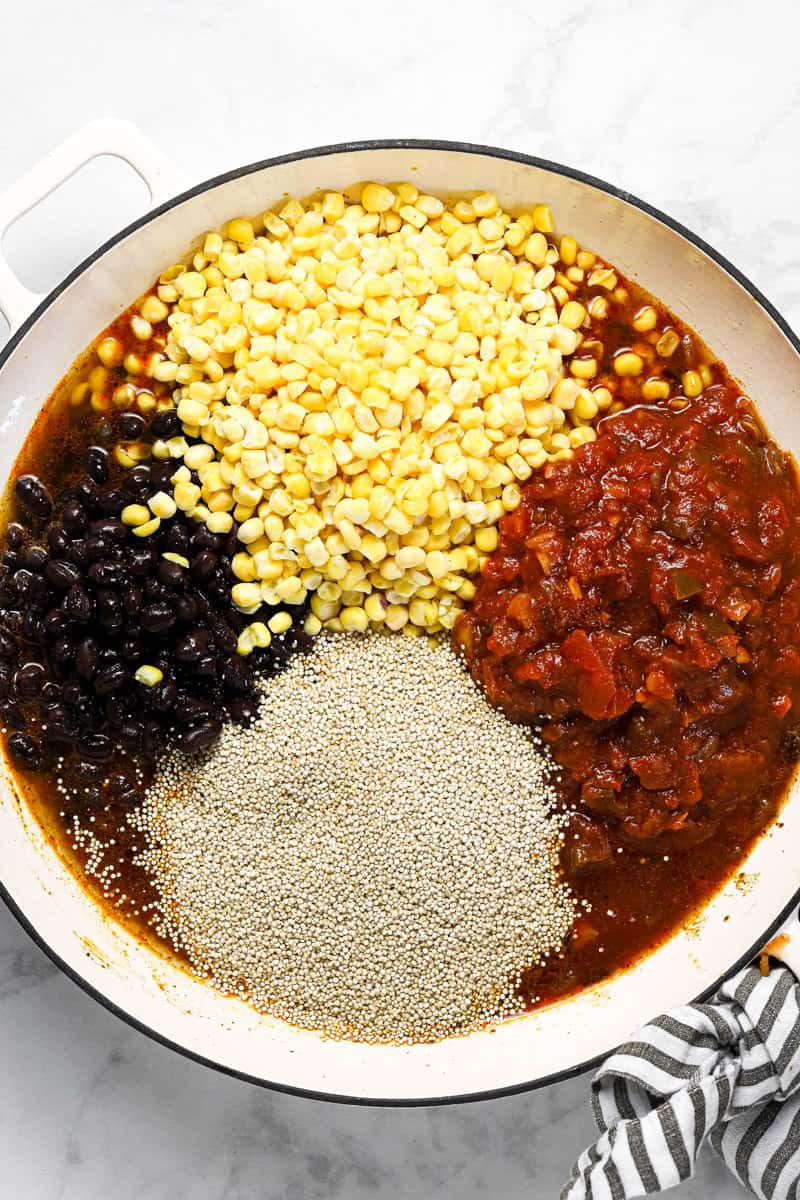 Ingredients to make Mexican quinoa in a large white pan