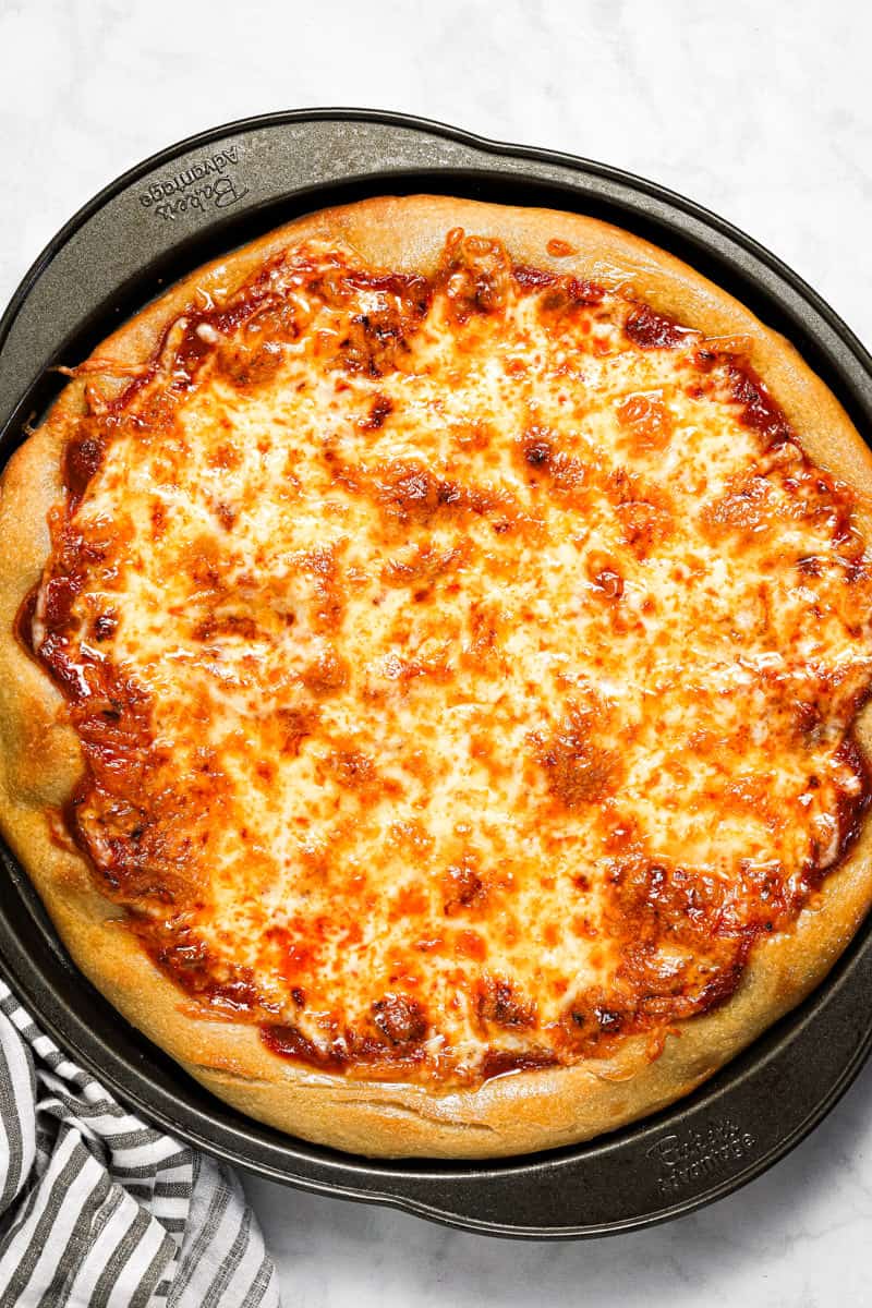 Overhead shot of a homemade cheese pizza on a pizza pan 