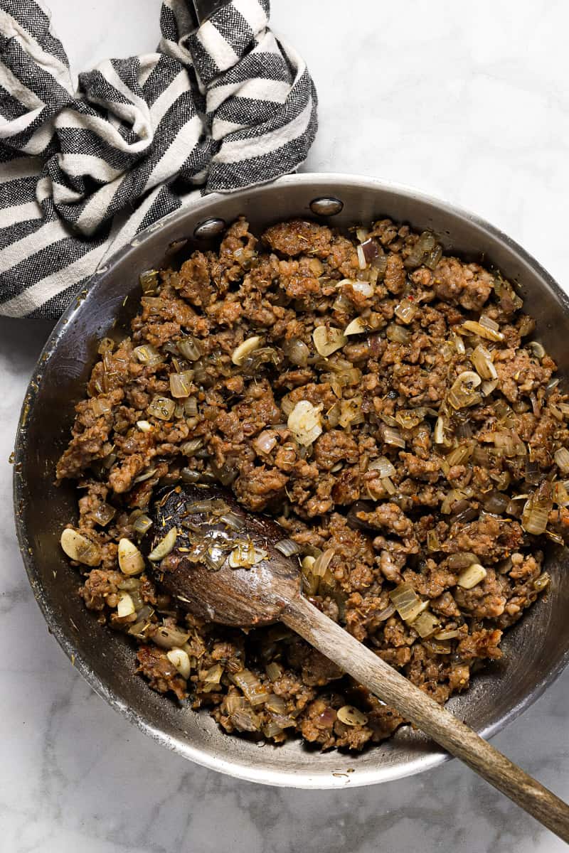 Large sauté pan with browned groudn sausage onion and garlic