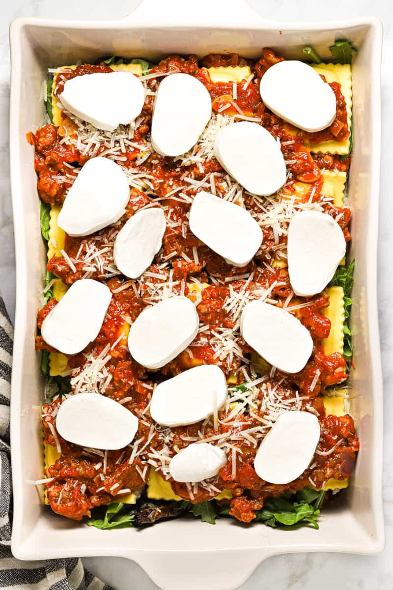 White baking dish filled with homemade ravioli lasagna ready to go in the oven