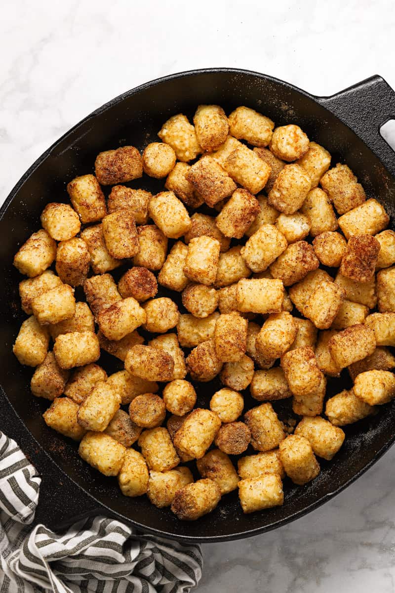 Seasoned tater tots in a cast iron skillet