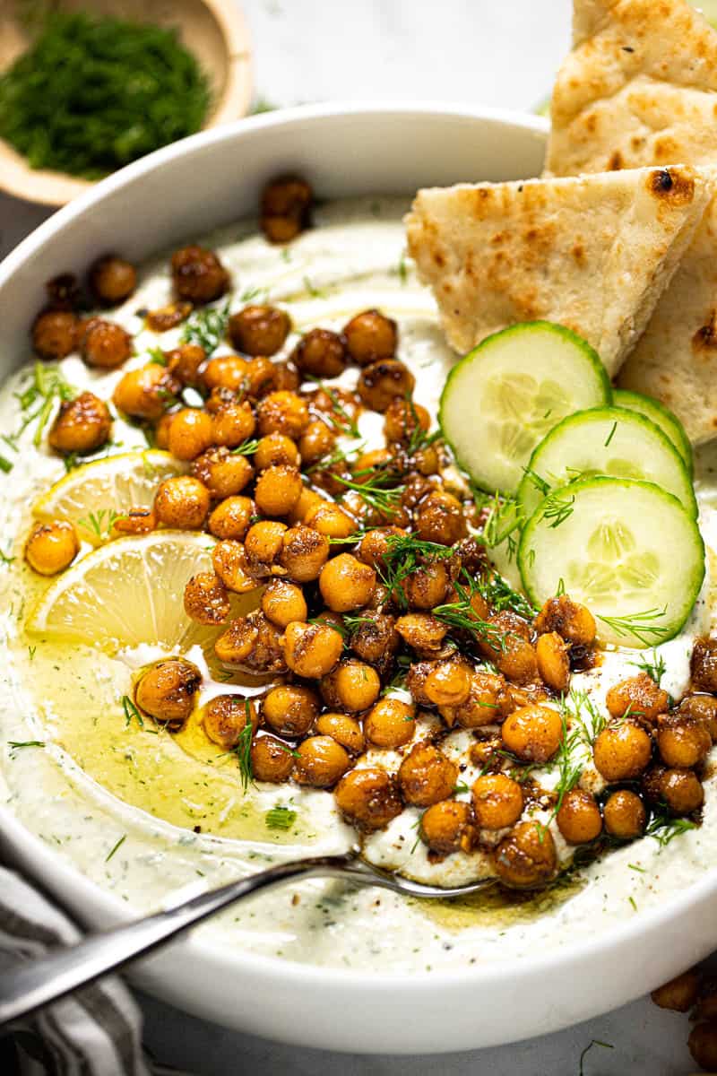 Close up shot of a white bowl filled with whipped feta topped with chickpeas