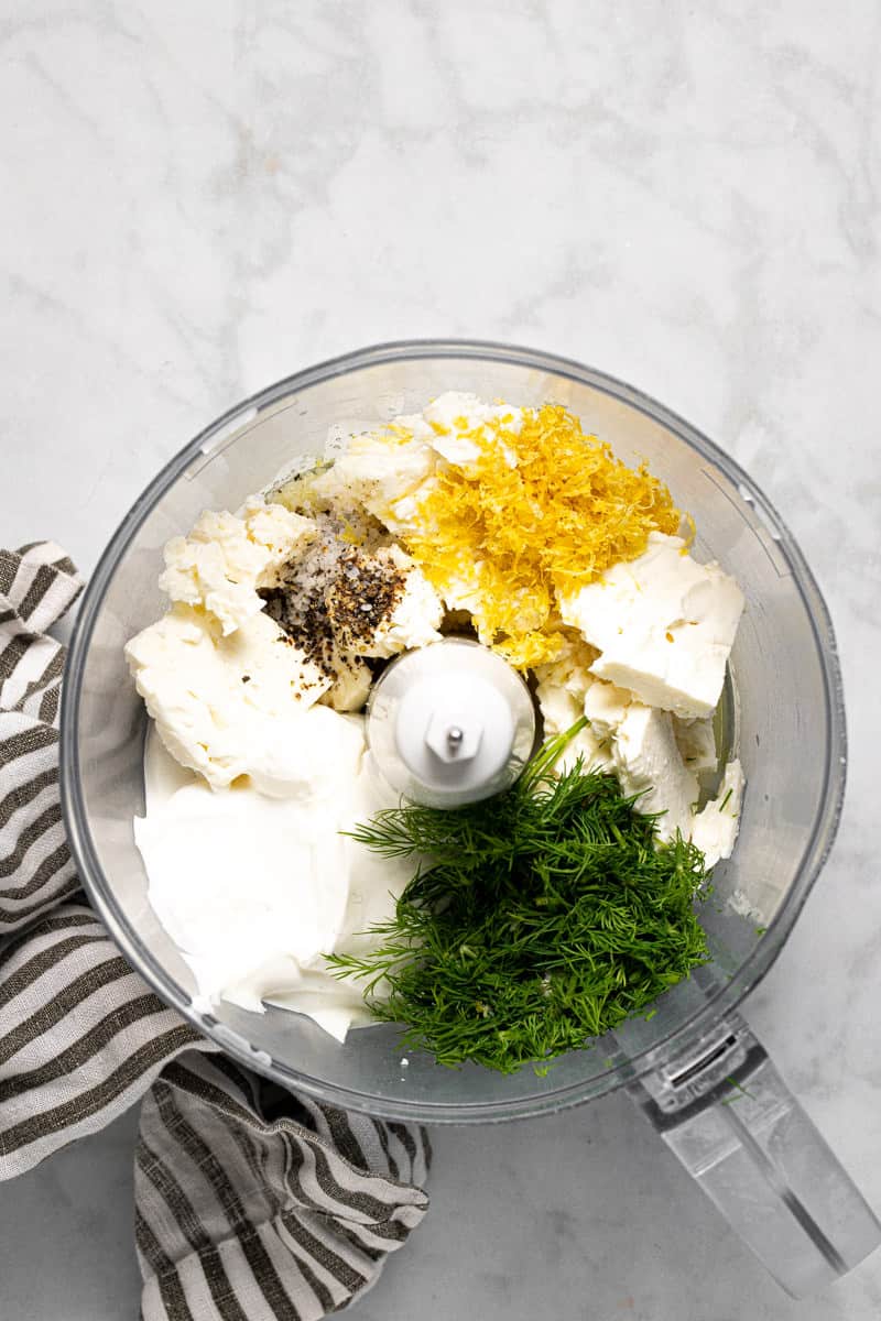 Food processor filled with ingredients to make whipped feta dip