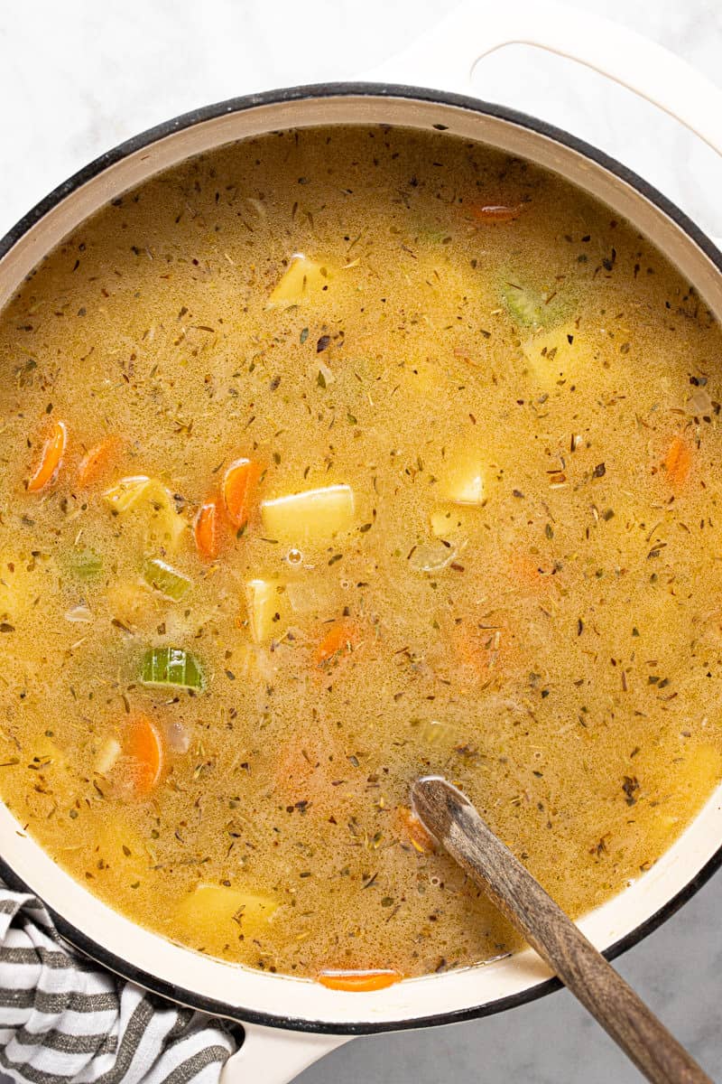 Large white pot filled with ingredients to make vegetarian beer cheese soup