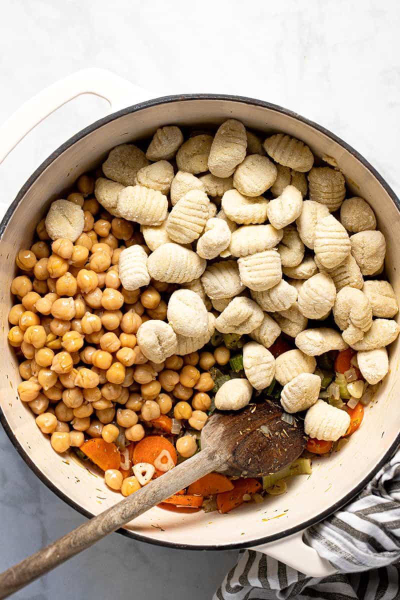 Large white pot filled with ingredients to make creamy vegan gnocchi soup