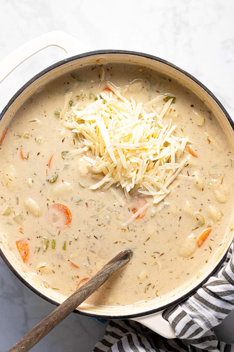 Large white pot filled with ingredients to make creamy vegan gnocchi soup