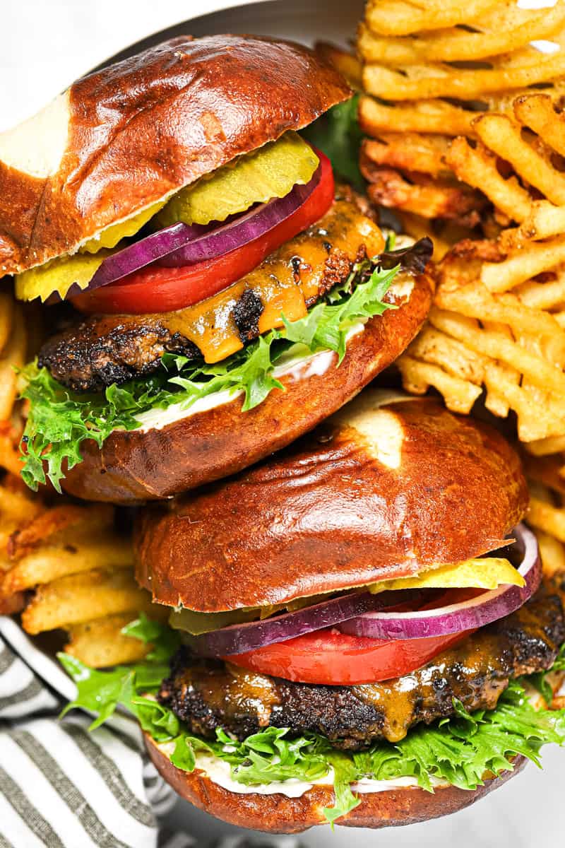 Overhead shot of a basket with two smash burgers and waffle fries in it