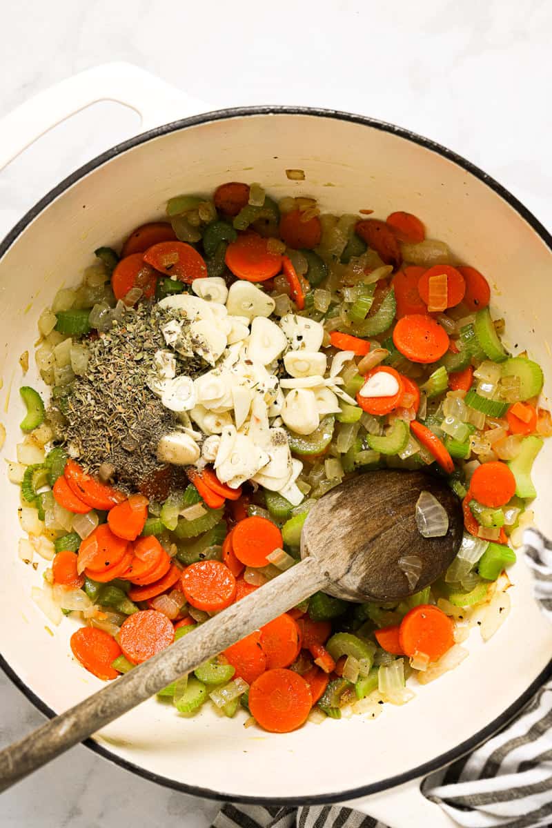 Large white pot with ingredients to make potato kale soup