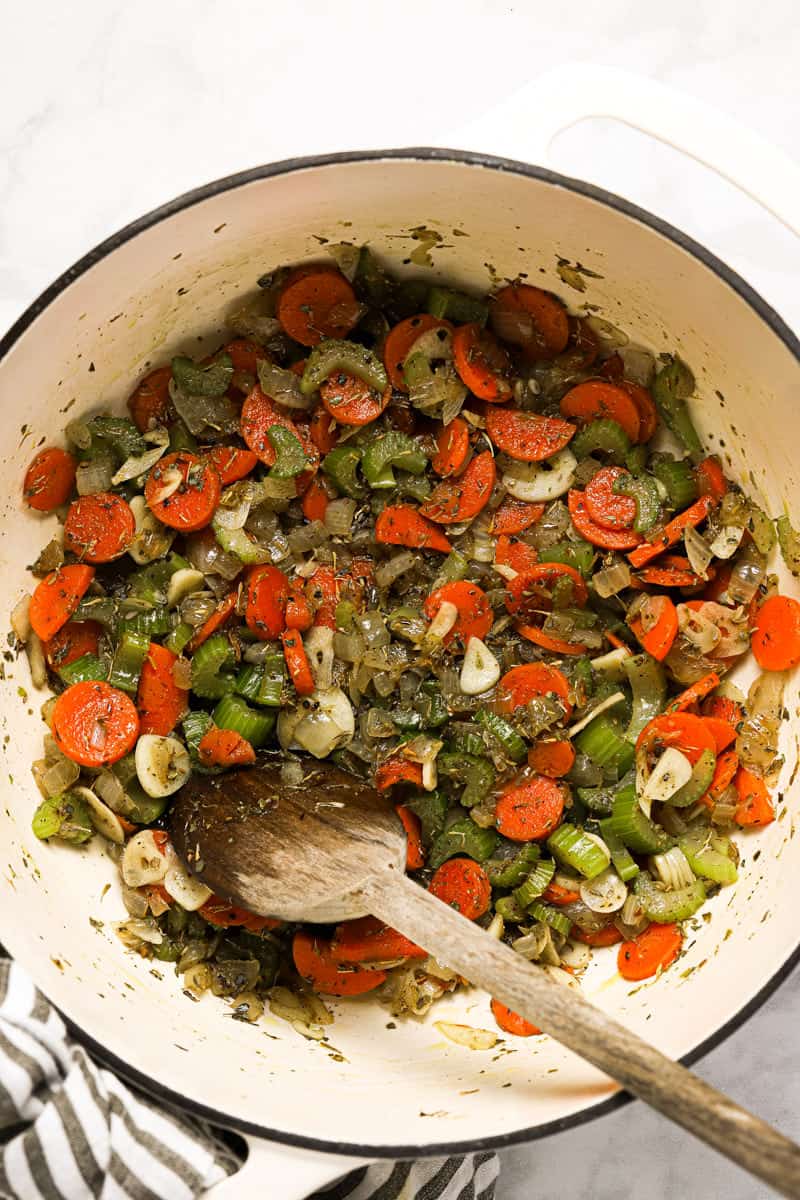 Large white pot with ingredients to make potato kale soup
