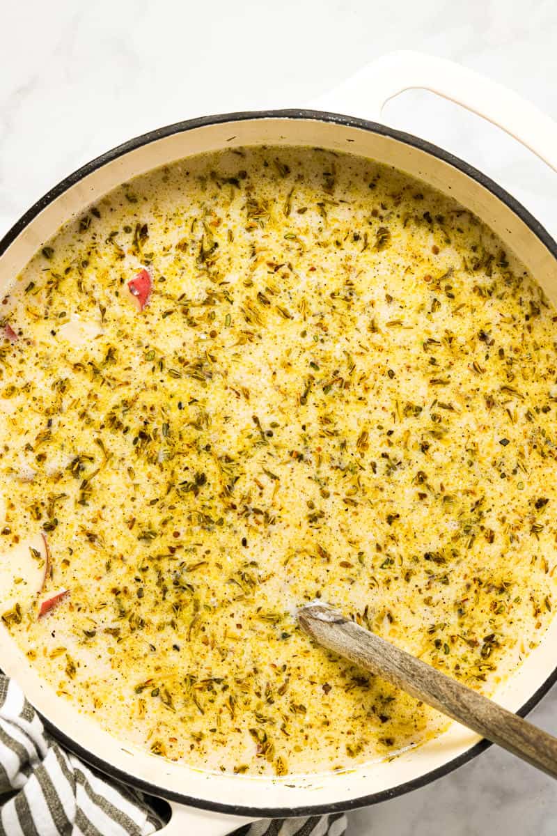 Large white pot with ingredients to make potato kale soup