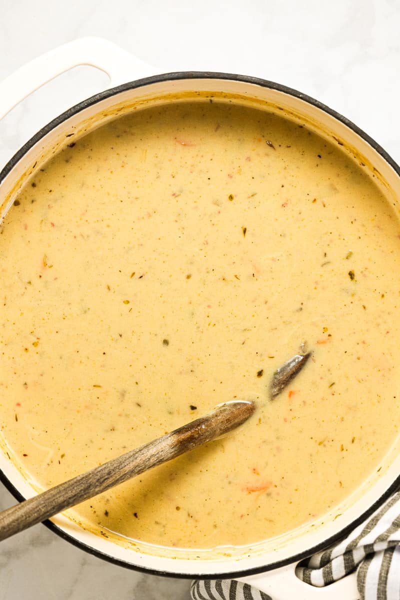 Large white pot with ingredients to make potato kale soup